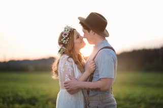 A newlywed couple looking at each other in the open fields of meadow valley ranch in Summerland BC